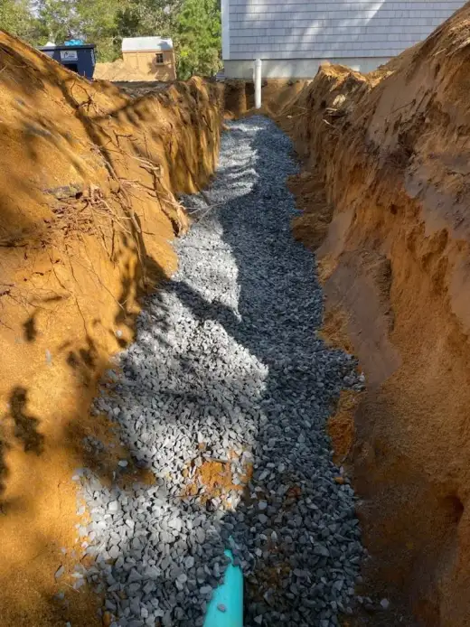 Excavated trench beside a house